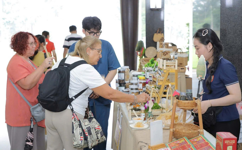 Du khách quốc tế thích thú với sản phẩm dự án khởi nghiệp tại sự kiện. Ảnh: Minh Khuê.
